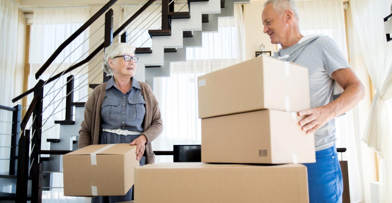 VRS portrait of happy senior couple packing cardboard boxes