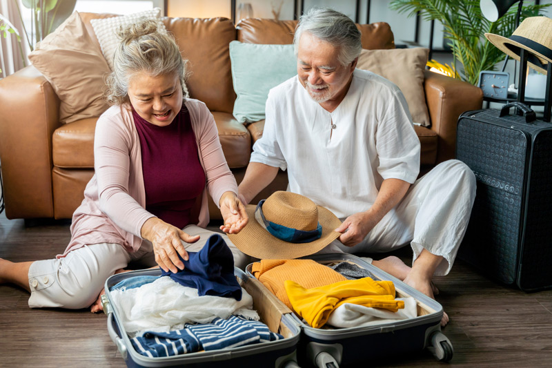 Senior Couple Packing Vacation Suitcase at a VRS Retirement Home