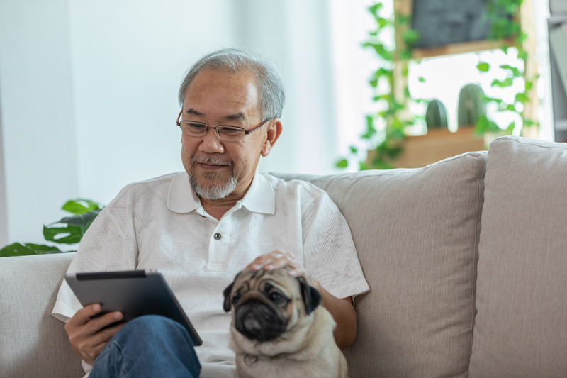 Senior on iPad tablet with dog at VRS retirement home