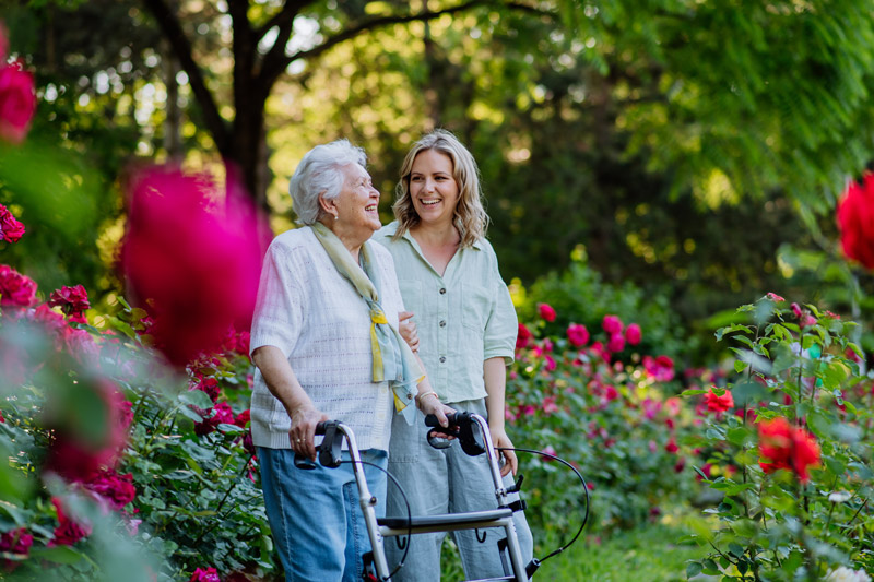 Senior safely walking outside with a walker at a VRS senior independent or assisted living community